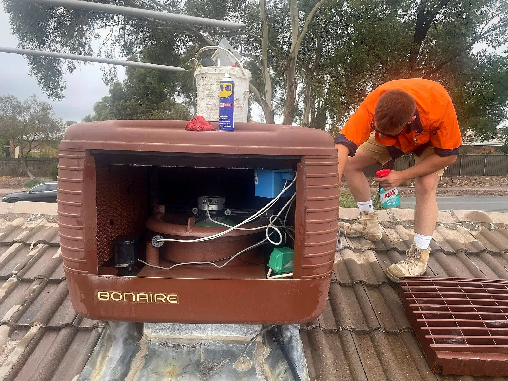 A Classic Air and Mechanical Services installer fitting a new evaporative cooling unit on a roof